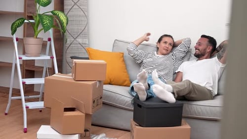 Couple Relaxing on Sofa After Moving In