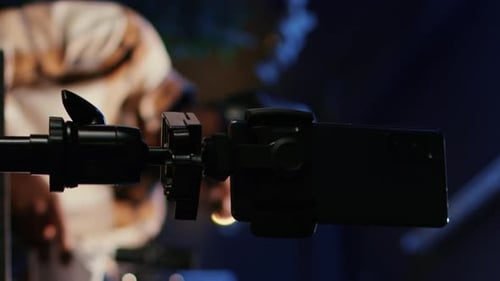 Vidéo verticale : smartphone sur trépied, enregistrement vidéo, vlogger, afficher l'hôte en arrière-plan flou, entretien