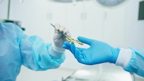 Surgical Scissors Exchanged in a Bright Operating Room
