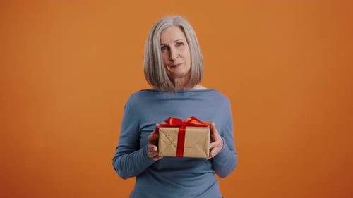 Happy Senior Woman Holding Birthday Gift