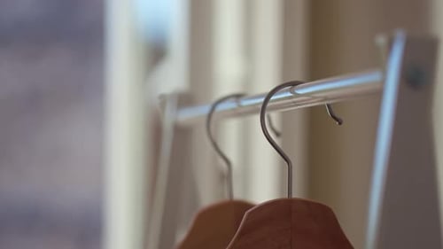Hand Removing Hanger from Closet Rack