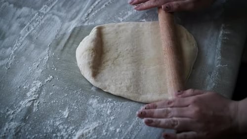 Woman Rolling Dough with Wooden Rolling Pin