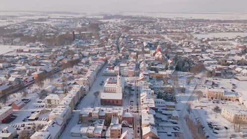 Snowy Town Center with Church Tower Rising Above Buildings in Winter