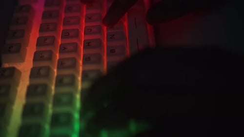 Nahaufnahme eines Teenagers, der eine Nachricht auf der RGB-Tastatur eingibt Cyber Sport Gamer Online-Spiel spielen
