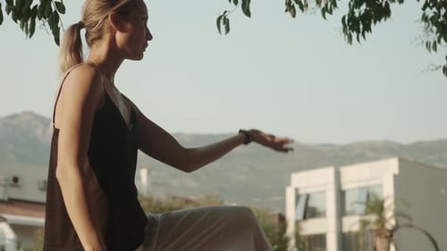Woman Practicing Tai Chi Outdoors in Urban Setting