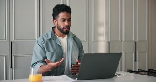 Man Talking on Laptop During Video Call at Home