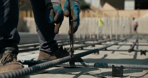 Worker Ties And Weaves Reinforcement Bars For Concrete Foundation