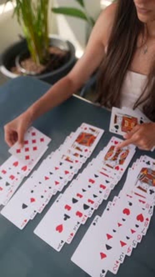 Jeune femme joue au solitaire en plein air au soleil en profitant d'un jeu de cartes stimulant et relaxant