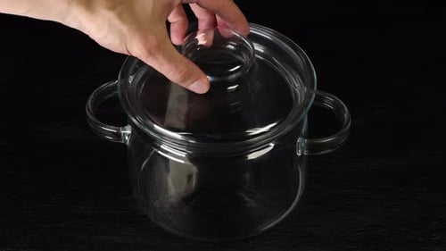 Hand Lifts Lid of Glass Cooking Pot