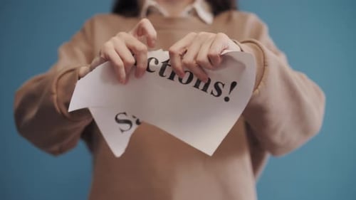 Woman Tears Up Sanctions Sign in Protest Against Policies