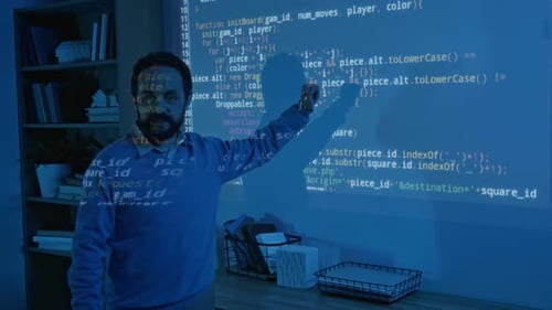 Biracial Male Coding Teacher Explaining Algorithm on Blue Projector Screen