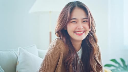 Smiling Young Woman Relaxing at Home on Couch