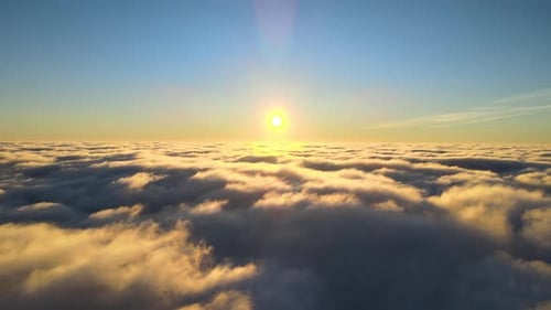 Luftaufnahme aus dem Flugzeugfenster in großer Höhe dichter, geschwollener Cumuluswolken, die am Abend fliegen