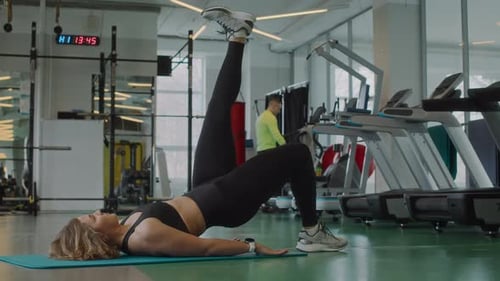 Young Woman Doing Single Leg Glute Bridge at Gym