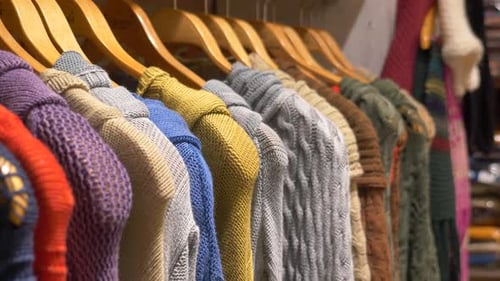 Colorful Knitted Sweaters on Hangers in a Boutique Showcasing Cozy and Fashionable Garments