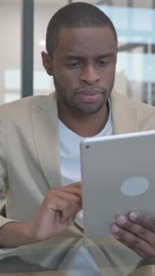 African Man using Digital Tablet in Office, vertical video