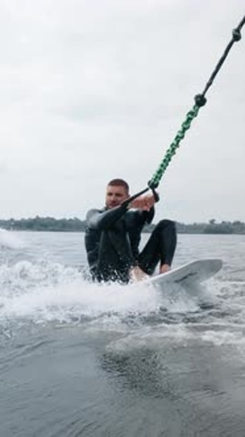 A Thrilling Experience A Surfer in a Black Wetsuit Riding the Waves Showcasing Skill and Balance
