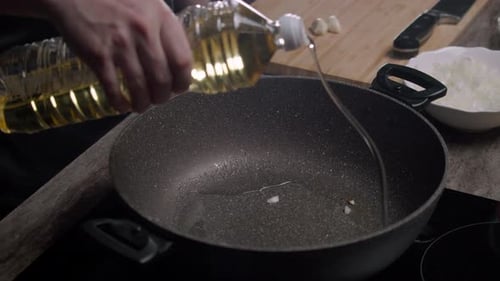 Adding Oil and Onions to a Pan for Cooking