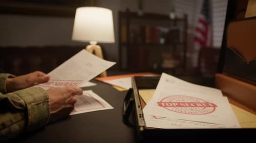 Man Reviews Top Secret Documents in Dark Room