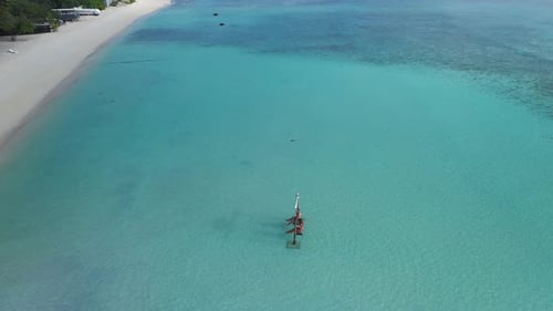 Aerial View of Honeymoon Couple on Swing in Shallow Sea Water by Maldives Island Beach
