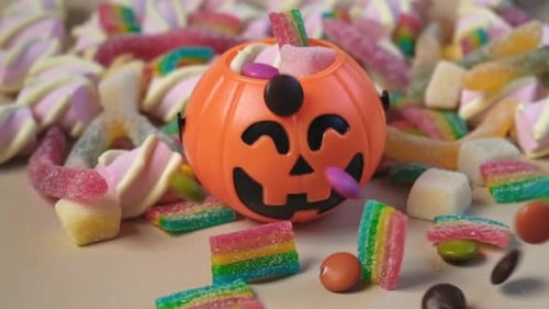 Halloween Pumpkin Container Surrounded by Colorful Candy