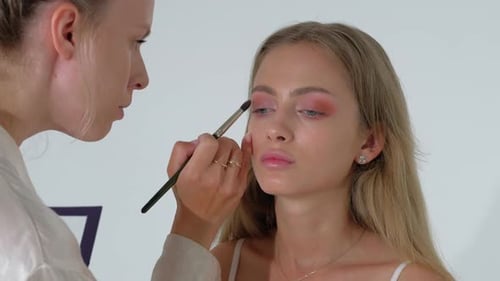 Makeup Artist Applying Eye Shadow on a Model