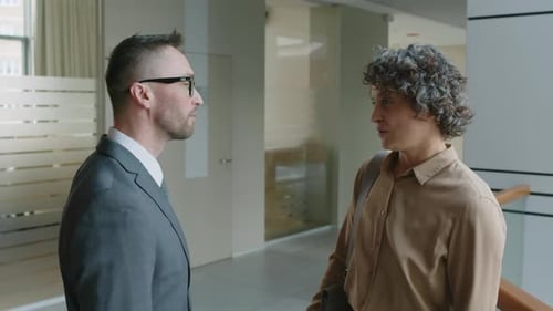 Business Partners Speaking in Office Atrium