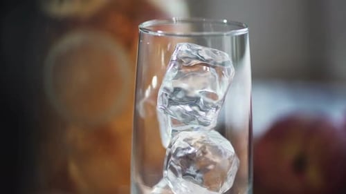 Refreshing Peach Tea Poured over Ice Cubes