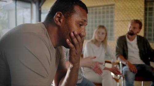 Man with Head in Hand in a Support Group