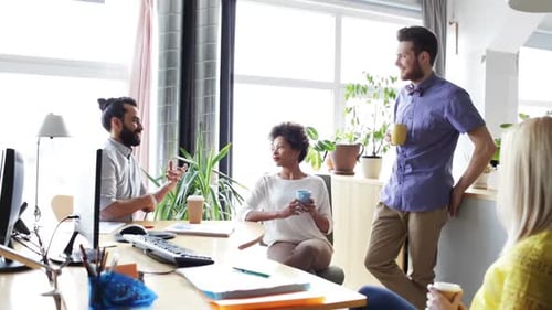 Team Having Casual Meeting in Office with Coffee