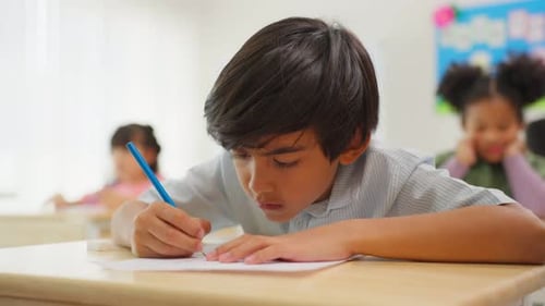 Adorable student learn with teacher in classroom at elementary school.