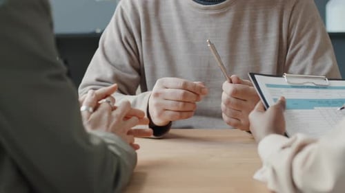 Three Adults Discussing Contract in Office Setting