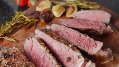 Delicious Sliced Steak on Cutting Board with Rosemary