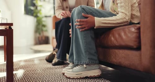 Two People Sitting and Talking on a Leather Couch