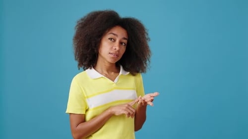 AfricanAmerican Woman Counts on Fingers on Blue Background