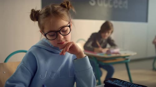 Dreamy school student focused on class work in auditorium classroom portrait