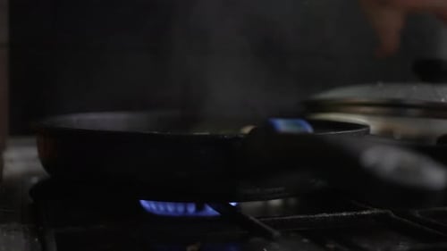A Woman Cooks Broccoli with Mushrooms in a Pan Cooks Food on a Gas Stove