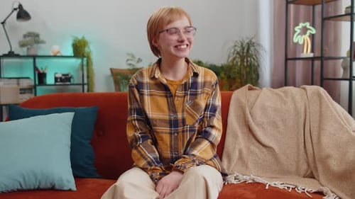 Happy Woman Relaxing on Couch Indoors