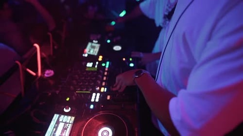 DJ Mixing Music in Crowded Nightclub with Colorful Lights