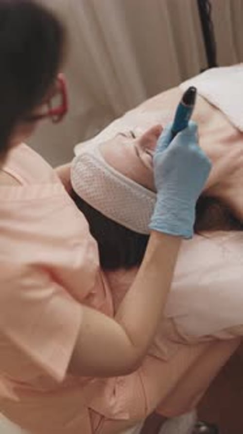 Cosmetologist Performing Microneedling Therapy in Clinic