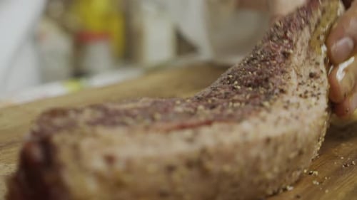 Meat steak oil massage on cutting board. Close up slow motion shot.