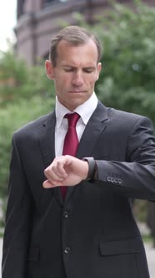 Man Checking Watch Standing Outside