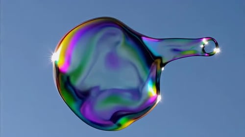 Eine bunte Seifenblase schwebt anmutig in einem klaren und hellen Himmel über uns