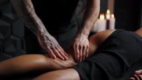 Woman Receives Leg Massage in Candlelit Room