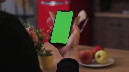 Tokio Japan April 7 2018 Woman Hand Hold Use Smartphone with Vertical Green Screen on Kitchen at