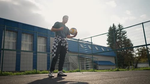 Athlete Bouncing and Slamming Volleyball During Training Session in Outdoor Arena