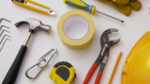 Various work tools arranged on a white background for building and repair projects