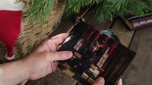 Mujer navegando por fotos familiares navideñas impresas