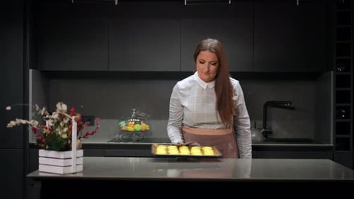 Woman Places Baked Goods on Counter