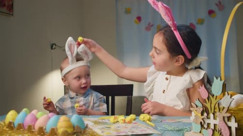 Cute Cheerful Children in Easter Bunny Costumes Color Eggs at Home at the Table